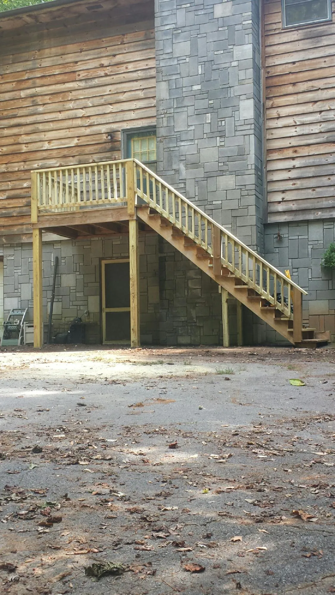 New pressure treated deck and stair landing on a log home in Laurel